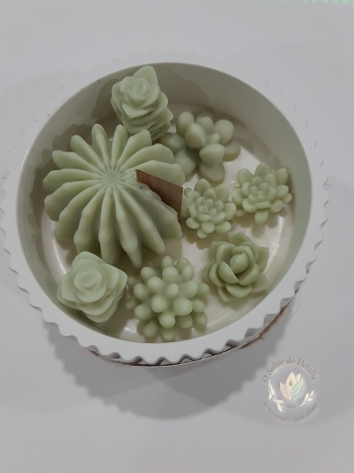 Conjunto de velas decorativas em formato de flores e suculentas verdes claras numa caixa branca