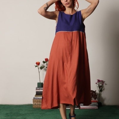 Vestido azul escuro e terracota com sandálias azuis plataforma em fundo branco e carpete verde