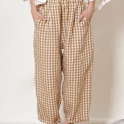 Calças compridas às quadrículas bege e branco com blusa branca e sandálias castanhas