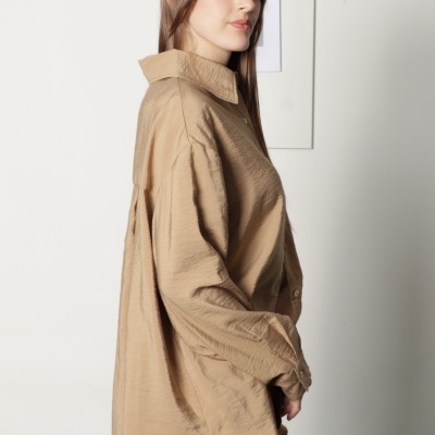 Camisa oversized bege claro com textura enrugada e calças castanho-avermelhadas