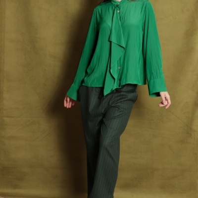 Pessoa com camisa verde, calças riscas finas e ténis cinzentos