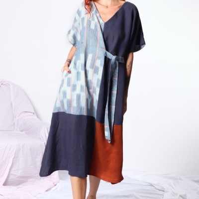Vestido midi azul claro e escuro com castanho, padrão abstrato, cinto, usado por mulher.