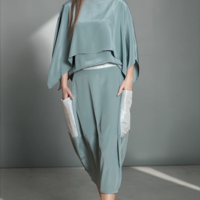 Conjunto verde-azulado dois peças com saia midi e blusa ampla com bolsos brancos