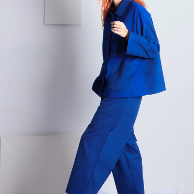 Mulher com roupa azul e sapatos pretos em fundo branco