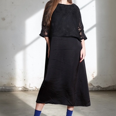 Vestido preto comprido de renda com meias e sandálias azuis.