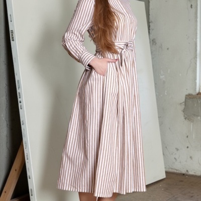 Vestido midi às riscas branco e castanho com ténis bege em fundo neutro