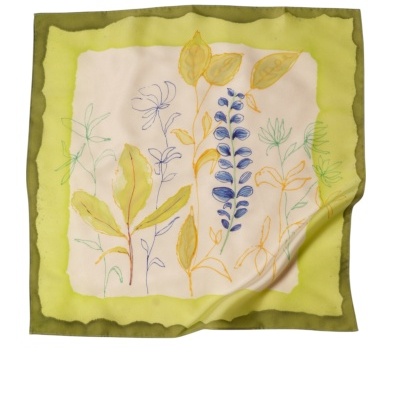 Lenço floral verde amarelo azul dobrado com fundo branco creme