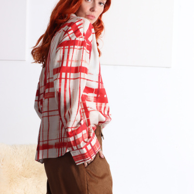 Camisa com padrão de riscas vermelhas e calças de veludo castanhas
