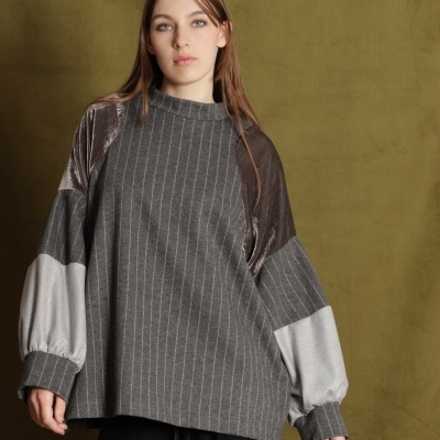 Camisola cinzenta às riscas com mangas largas em cinza e castanho, com calças pretas