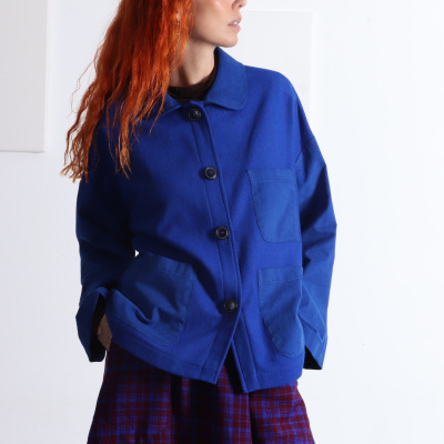 Casaco azul com botões e bolsos frontal, combinado com saia xadrez azul e vermelho