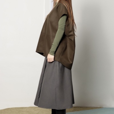 Mulher com roupa de outono em ambiente interior com chão azul e bege