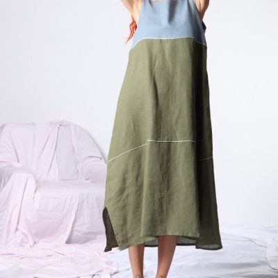 Vestido azul e verde de linho com linhas brancas numa modelo com sandálias verdes e fundo branco.