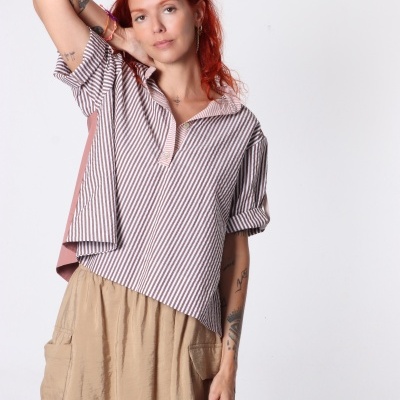 Mulher com camisa às riscas castanho e branco e saia beige