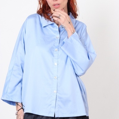 Camisa azul claro de manga comprida e calças cinzentas escuras