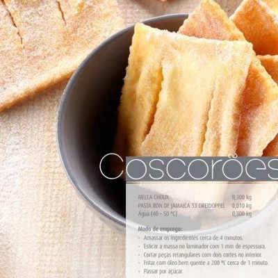 Coscorões dourados crocantes numa taça preta sobre superfície clara