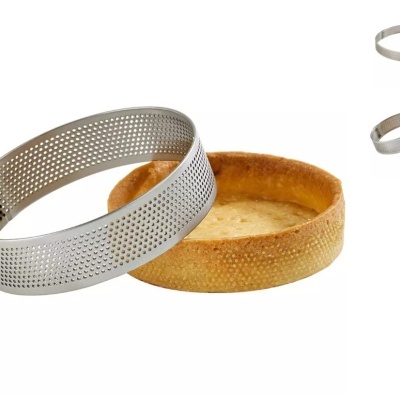 Forma redonda metálica perfurada e base de tarte de massa folhada