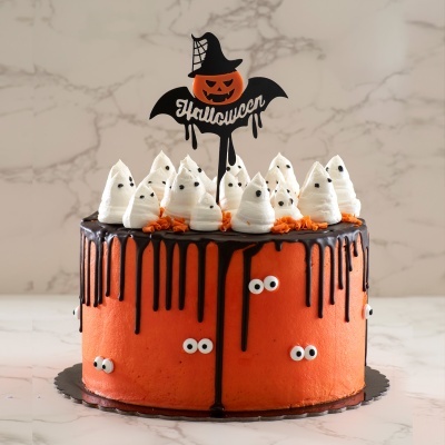 Bolo decorado para Halloween com chantilly branco em forma de fantasmas e cobertura drip preta sobre creme laranja