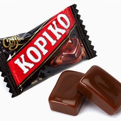 Doce Kopiko em embalagem preta e vermelha com duas balas castanhas à frente