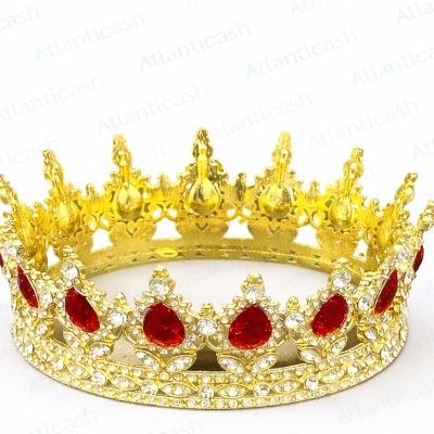 Coroa dourada decorativa com pedras vermelhas e brilhantes em fundo branco