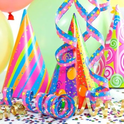 Chapéus de festa coloridos com serpentinas, confetti e balões ao fundo