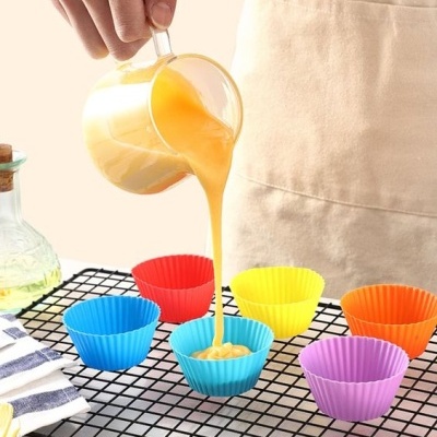 Formas de silicone coloridas numa grelha preta com massa a ser vertida