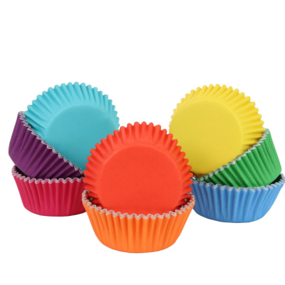 Formas de papel para muffins coloridas empilhadas em fundo branco