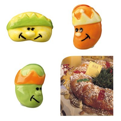 Três imãs em forma de feijões sorridentes coloridos e foto de bolo decorado com frutas cristalizadas