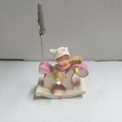 Peça decorativa de bebé num cavalo de baloiço rosa com suporte para fotos ou notas