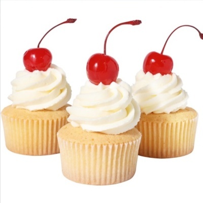 Três cupcakes com coberturas de creme e cerejas em fundo branco