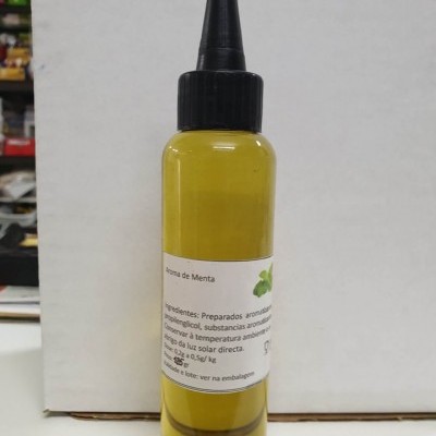 Frasco plástico com líquido amarelo e tampa preta de bico fino com rótulo branco e folhas de hortelã