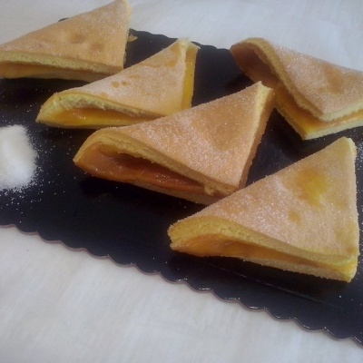 fatias de bolo triangular com açúcar em pó sobre tabuleiro preto