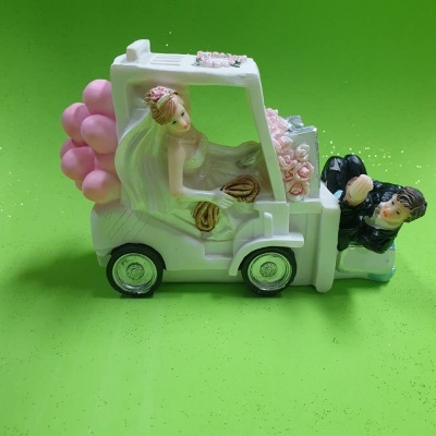 Figura decorativa de noiva e noivo em veículo branco