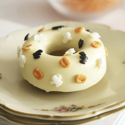 donut branco com decoração colorida num prato de porcelana com flores