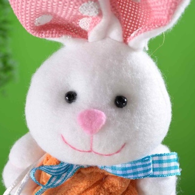 Boneco de pelúcia coelho branco segurando cenoura laranja com fita azul xadrez