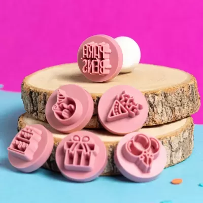 Conjunto de carimbos de silicone rosa com desenhos de festa sobre discos de madeira