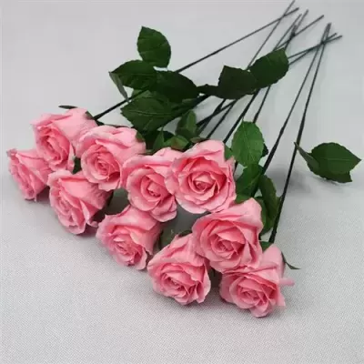 Oito rosas artificiais cor de rosa com folhas verdes sobre fundo branco