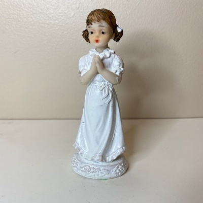 Figurinha menina de cerâmica com vestido branco e mãos postas em oração