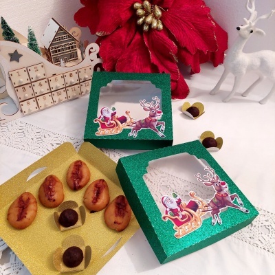 Caixas de presente verdes com doces e decoração natalina