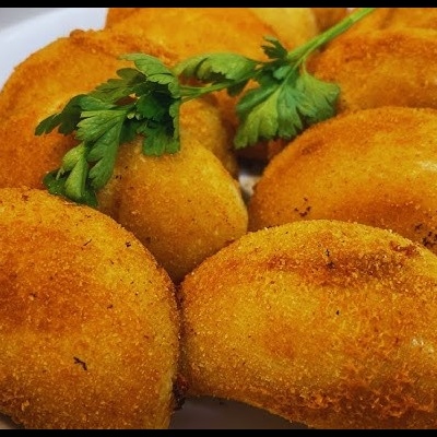 Prato branco com pastel frito dourado e folhas de salsa