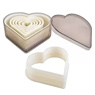 Conjunto de cortadores de bolacha coração, plástico branco, dentro de caixa cinza translúcida em forma de coração