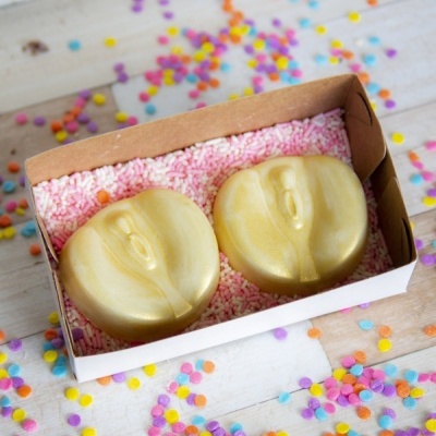 Dois sabonetes dourados em caixa de cartão com granulados cor-de-rosa e confetis coloridos