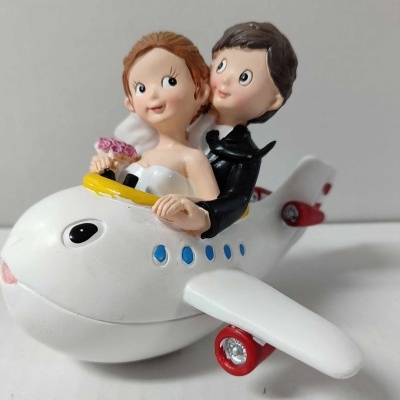 Figura decorativa de noivos em avião branco colorido