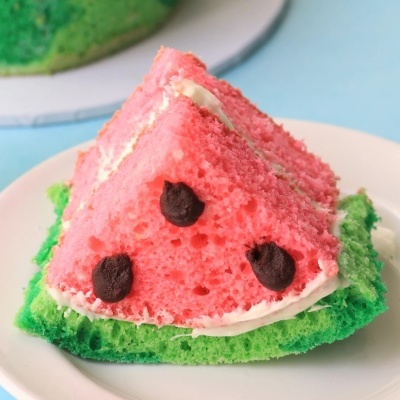 Fatia de bolo decorada com temas de melancia em prato branco