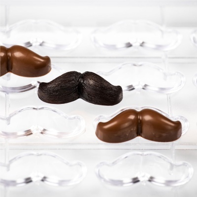 Chocolates em forma de bigode em molde transparente.