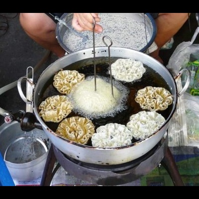 Panela metálica a fritar salgados numa banca de comida de rua