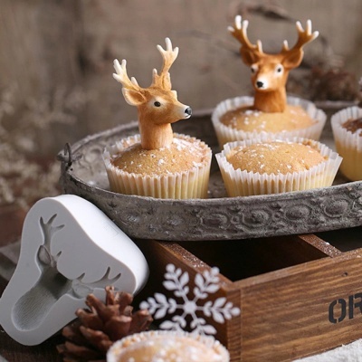 Bolos com decoração de veados em forminhas brancas num tabuleiro metálico e forma de silicone branca com relevo de veado