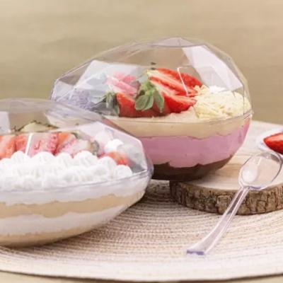 sobremesas em recipientes plásticos transparentes com tampas facetadas, decoradas com morangos e chantilly