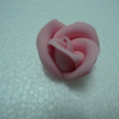 Flor rosa artificial em superfície branca texturizada