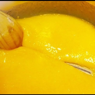 Tacho com puré amarelo e colher de pau