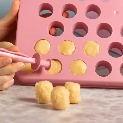 Aplicador rosa a preencher forma de silicone rosada com recheio amarelo.